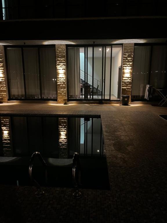 a building with a reflection in the water at night at Green Vista in Māḩiş