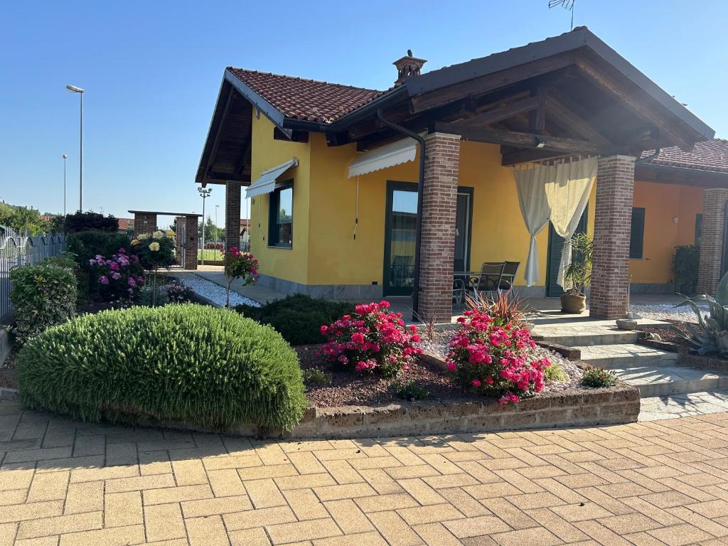 a yellow house with a porch and some flowers at Ca Sofia in Cervere
