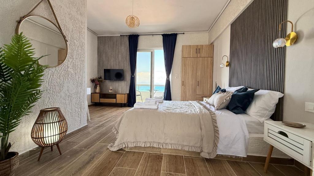 a bedroom with a large bed with a view of the ocean at Beachfront Studio with Panoramic Sea View 2 in Ialysos