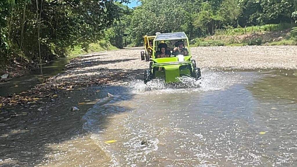 Eine Gruppe von Menschen fährt in einem Golfwagen auf einem Fluss in der Unterkunft Frailin Merete in San Felipe de Puerto Plata