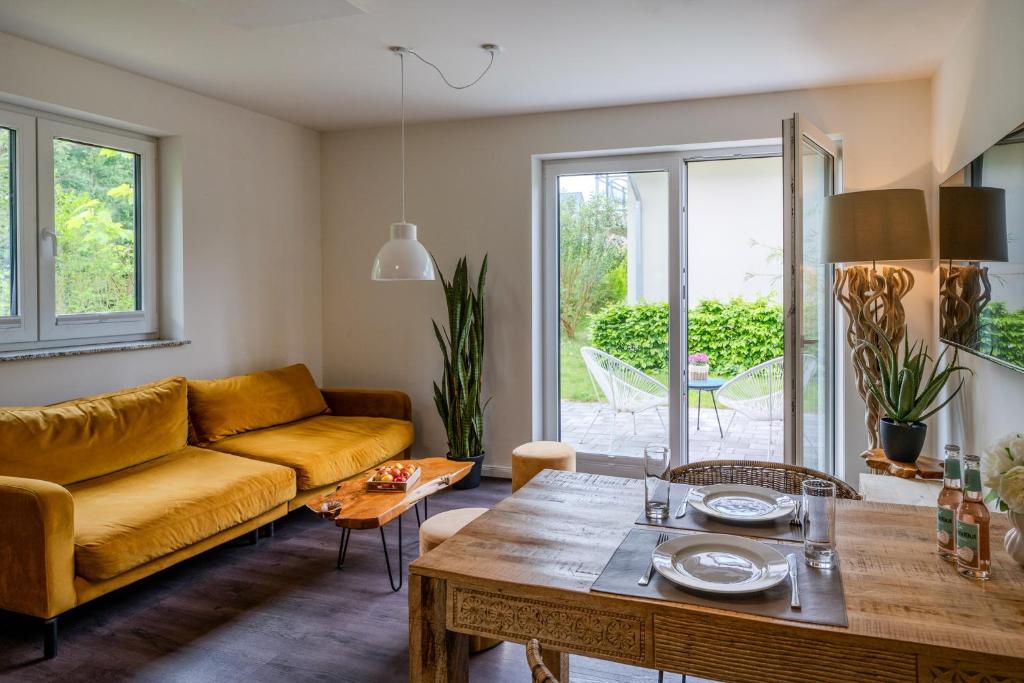 a living room with a yellow couch and a table at Dünenquartier Apartment 24 in Zingst