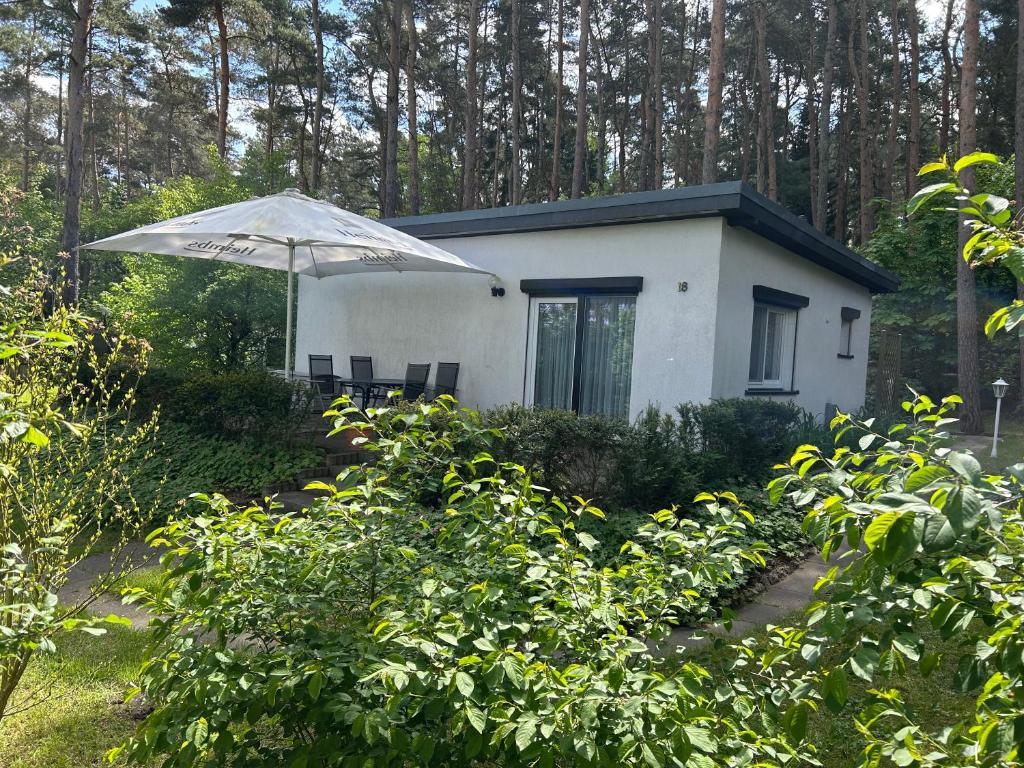 a small white house with an umbrella in front of it at Ferienhaus Stefanie in Plodda
