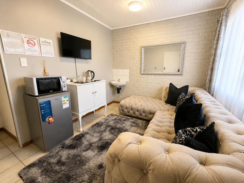 a living room with a couch and a television at Zhantique Guest House 2- Unit 12 in Boksburg