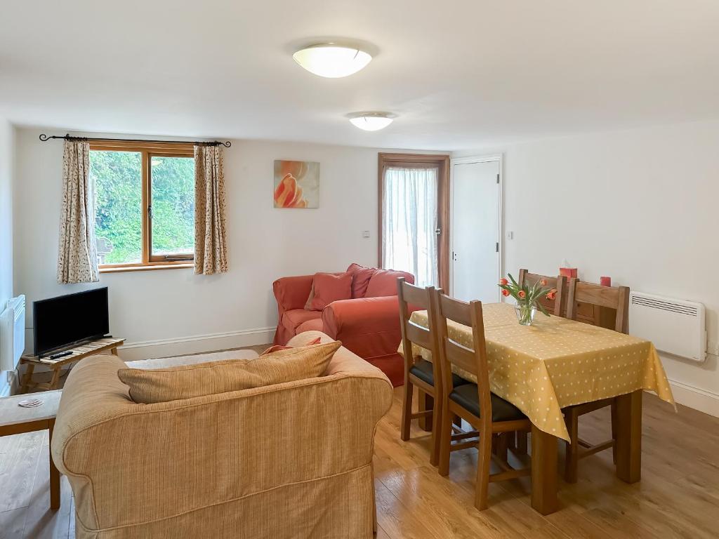 a living room with a couch and a table at The Old Sawmill One - Uk49336 in Plumpton Green