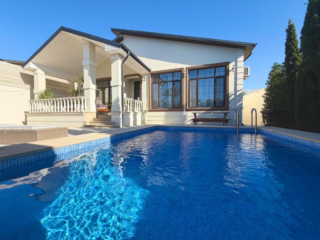 a house with a swimming pool in front of a house at Seaside Luxe Villa in Bilgah