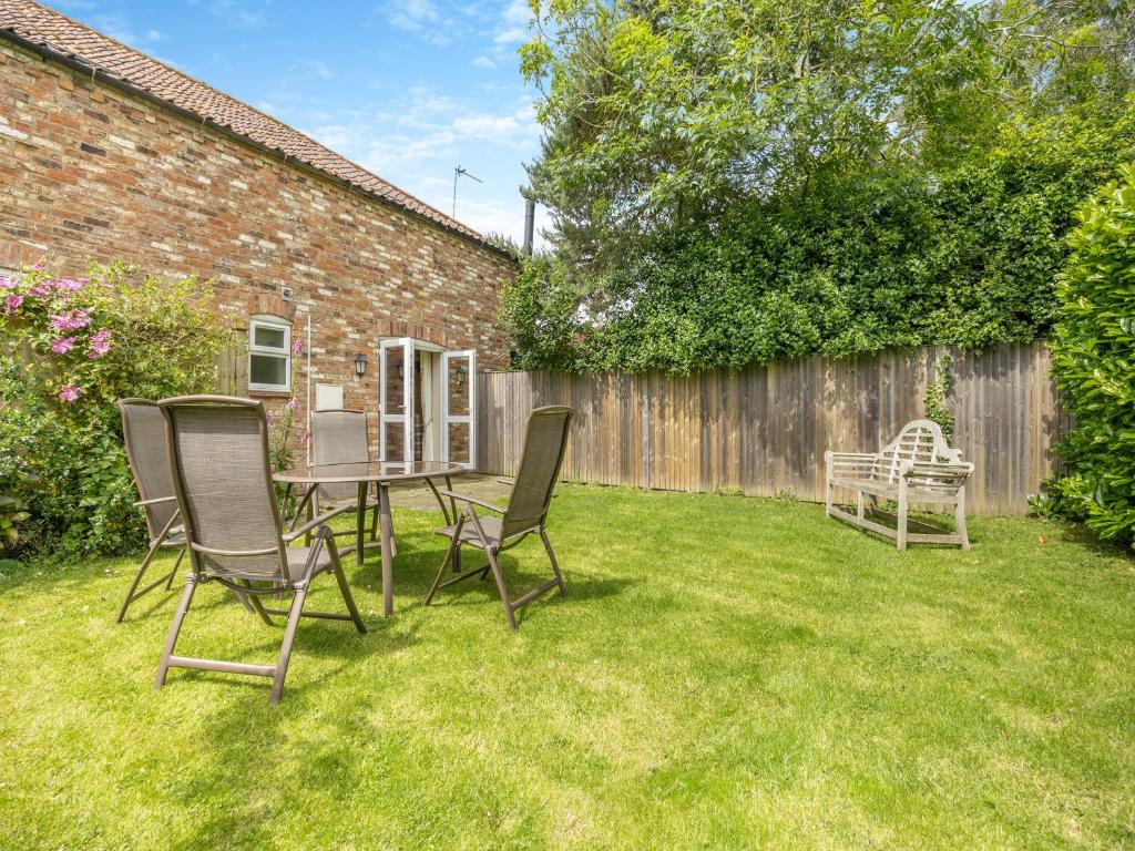 a yard with two chairs and a table and a fence at The Lilac-Uk47149 in Burgh le Marsh