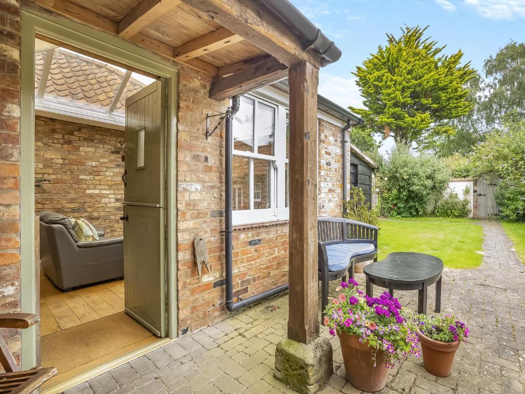 an open door to a brick building with a patio at The Stables - Uk47151 in Burgh le Marsh
