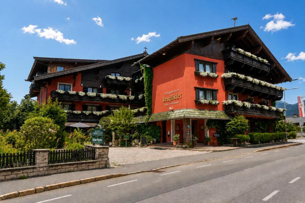 a red building on the side of a street at Hotel Bruggwirt in Sankt Johann in Tirol
