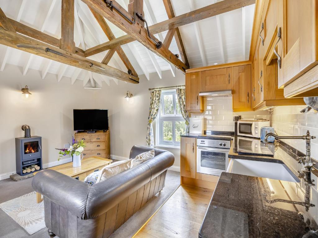 a living room with a couch and a stove at The Hayloft - Uk47153 in Burgh le Marsh