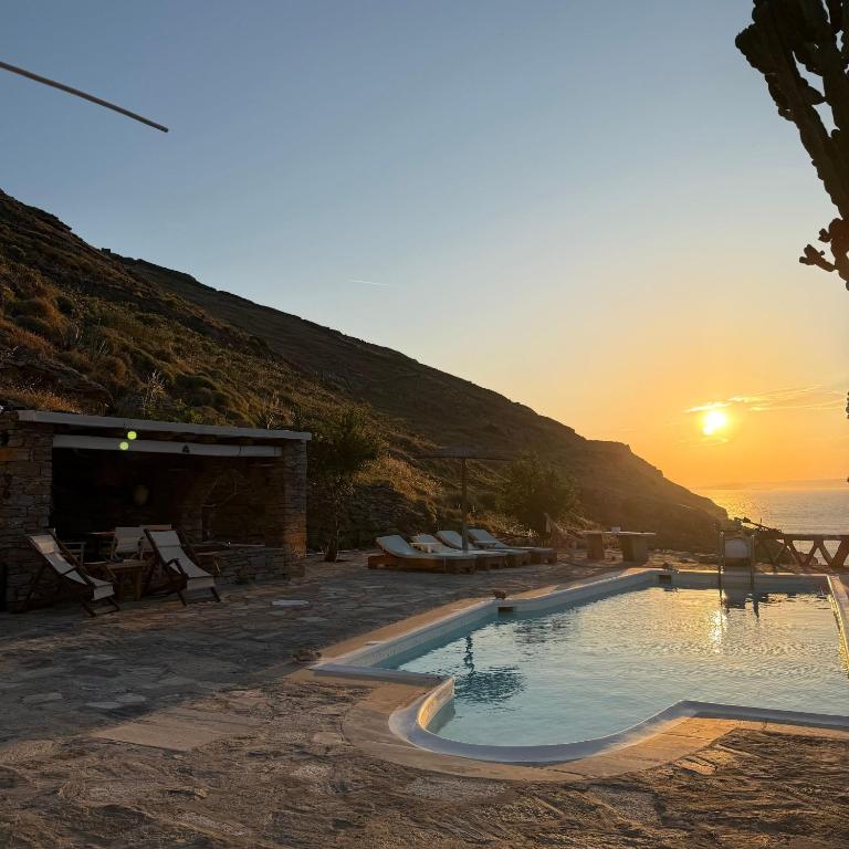 a swimming pool with the sunset in the background at Sun Holiday Kea Private Pool Sea View in Pisses