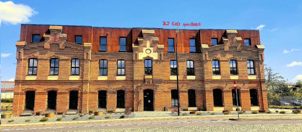 a large brick building with a clock on it at K2 Loft apartHotel in Gliwice