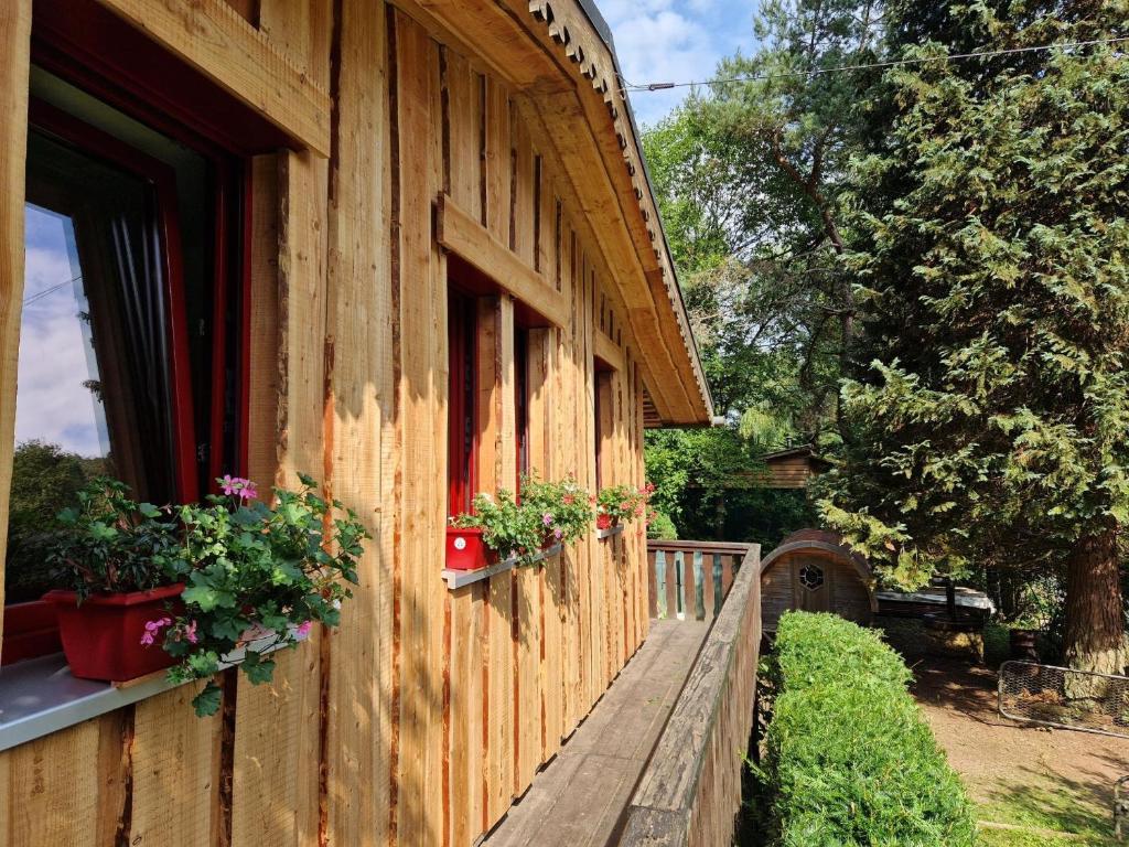 a building with potted plants on the side of it at Chalet De La Forêt - 6 personnes in Saint-Sauveur