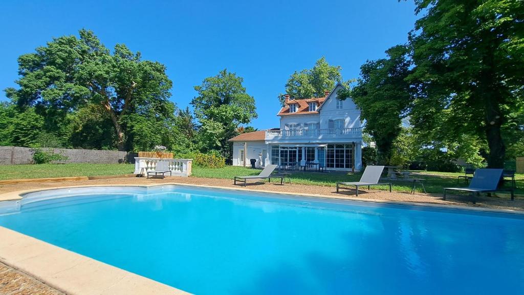 a large swimming pool in front of a house at Grandiflora in Saint-Julien-en-Born