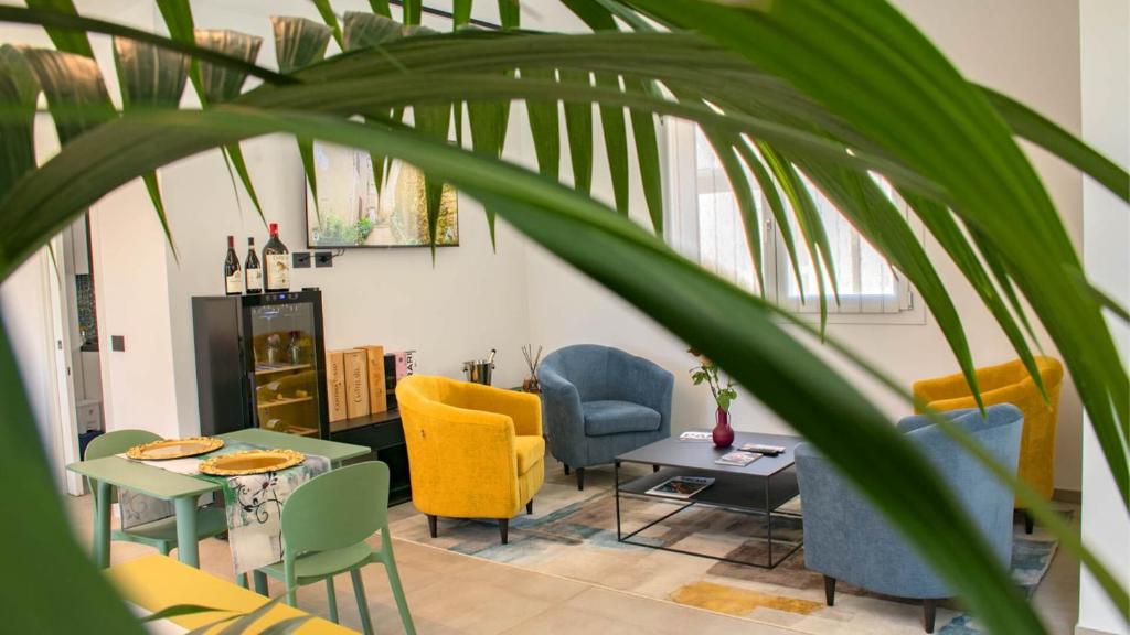 a living room with colorful chairs and a table at Dimora 5 Sensi in Pozzuolo del Friuli