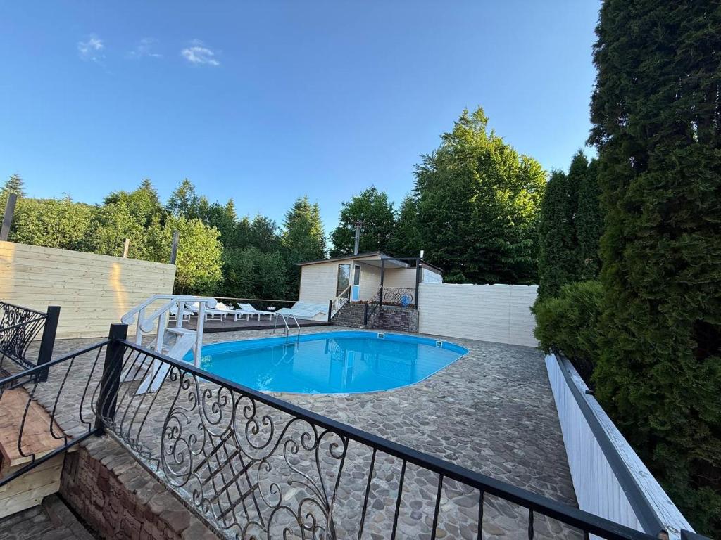 a swimming pool on a patio with a fence at Ватрич House in Chernivtsi