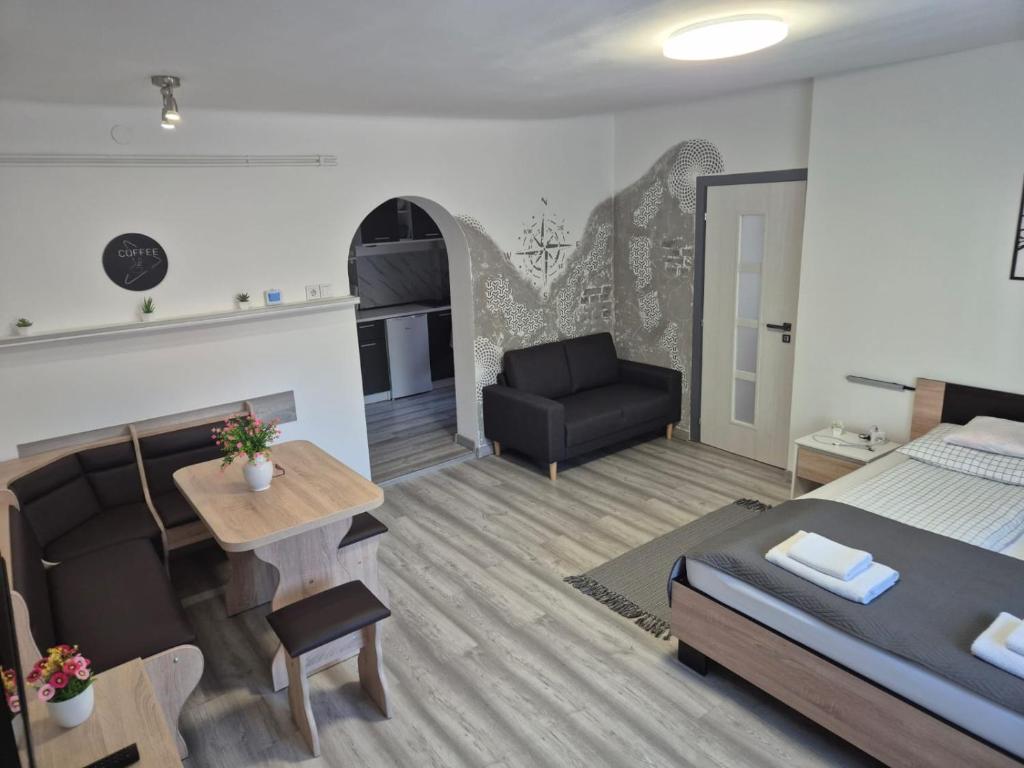 a bedroom and living room with a bed and a table at Kucko Vendeghaz Guesthouse in Sárospatak