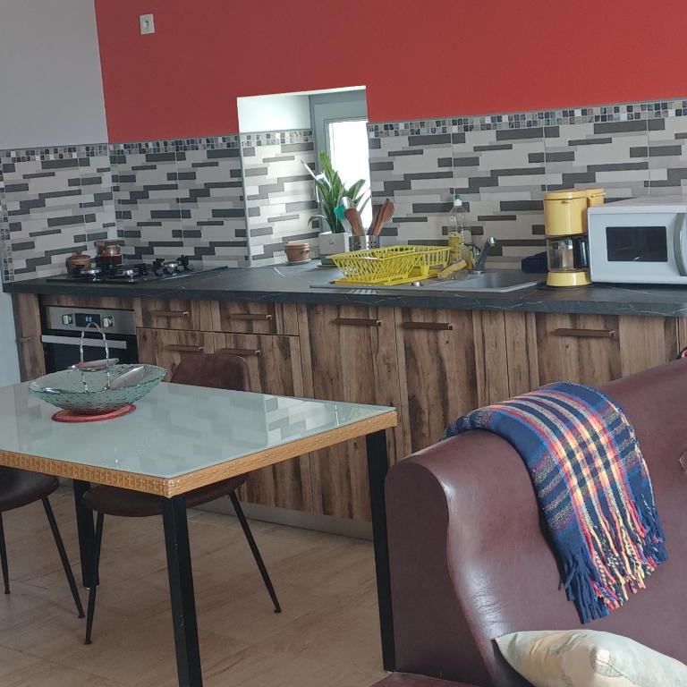 a kitchen with a counter and a table with a table sidx sidx at Escale en sud Charente in Chavenat