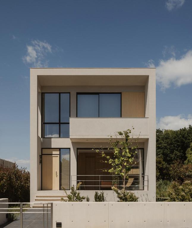 a house with a white fence in front of it at The Habitus Residence, a Design house in Corfu