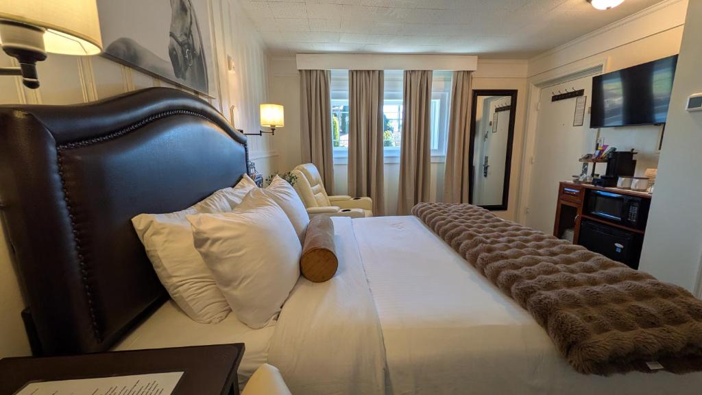a hotel room with a large bed with white pillows at Amherst Inn - Virginia in Amherst