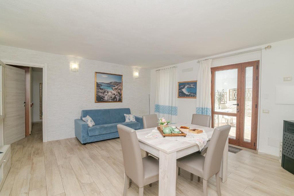 a living room with a table and a blue couch at Casa Flock in La Maddalena