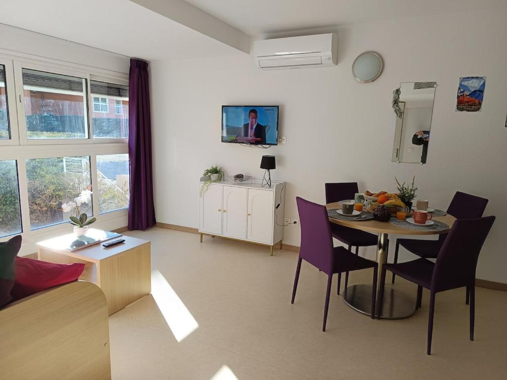 a living room with a table and purple chairs at Cami del Canigou in Vernet-les-Bains