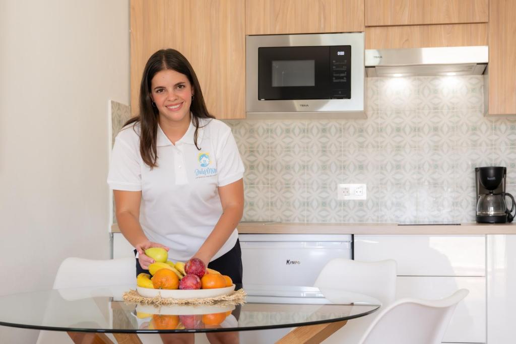 a woman standing in a kitchen with a bowl of fruit at La casa de Samuel y Laia in Costa Calma