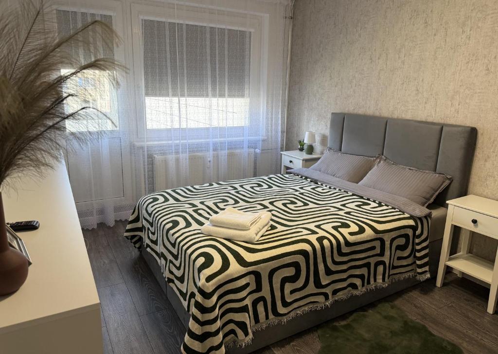 a bedroom with a large bed with a black and white blanket at Ventos g 51 Apartment in Mažeikiai