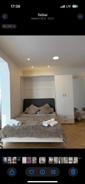 a room with a bed with two towels on it at Cozy city centre apartment in Telšiai