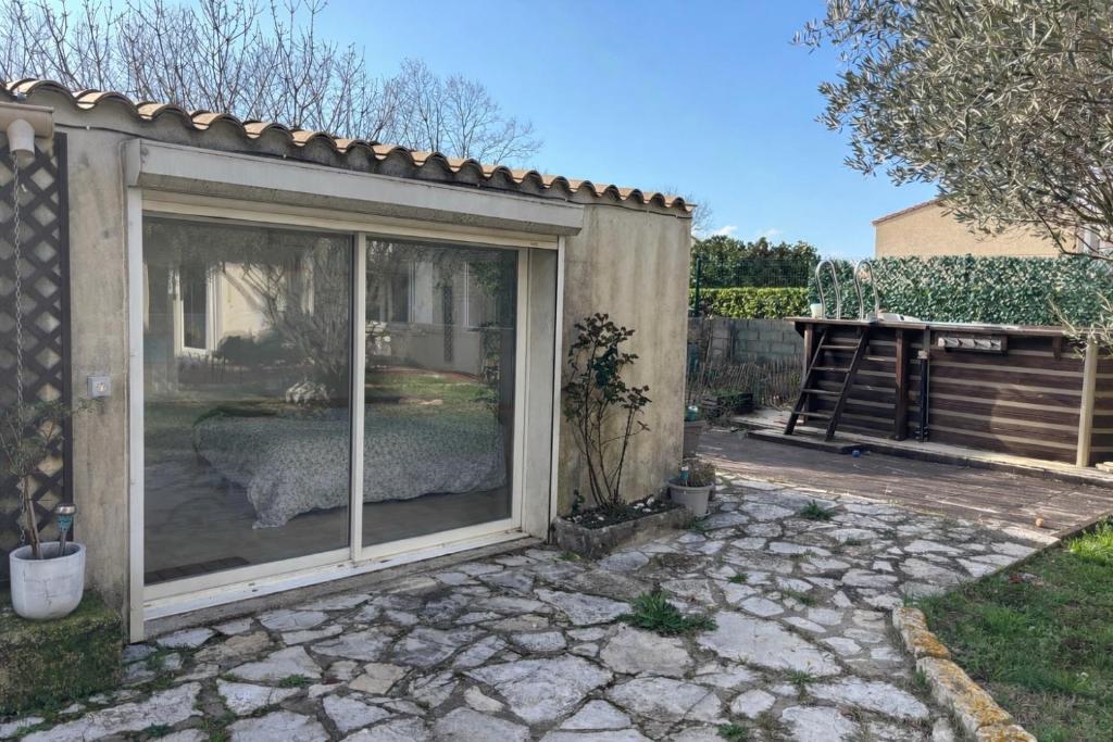 a large sliding glass door in a backyard at Studio cosy avec accès jardin in Lunel-Viel