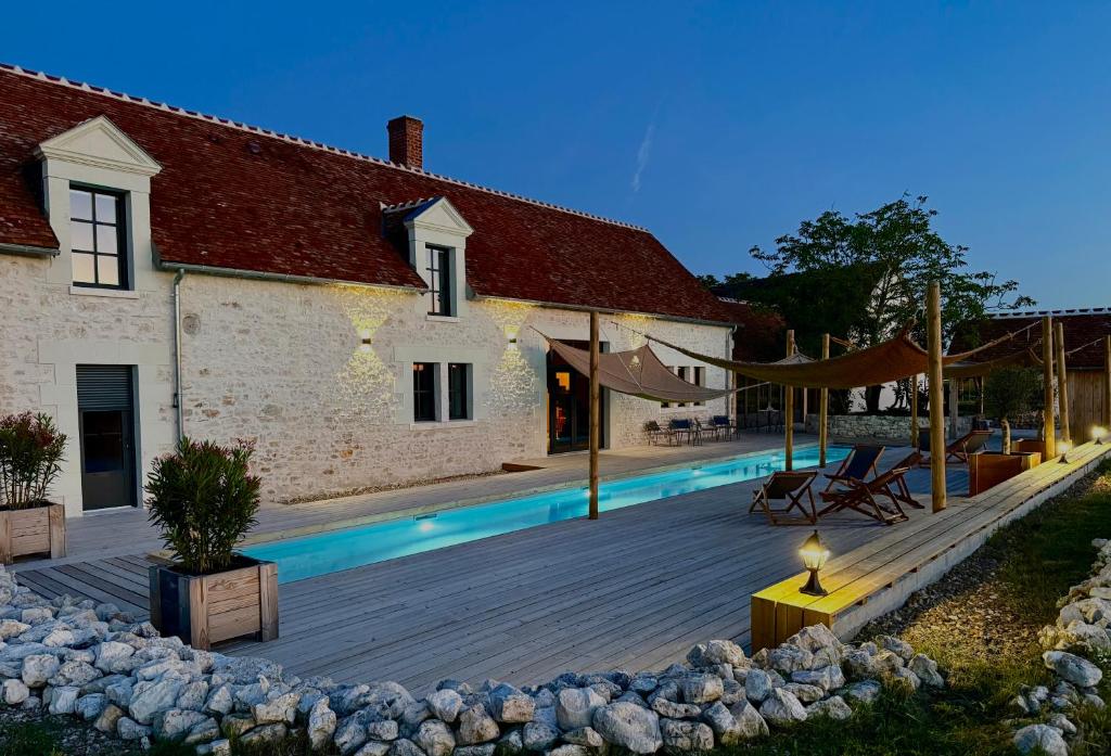 a house with a swimming pool next to a building at Au Détour des Châteaux in Méhers