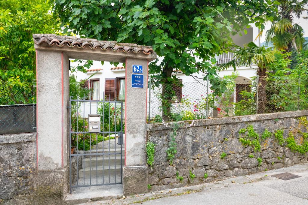 a gate with a sign in front of a fence at Apartman Maria Pia in Lovran