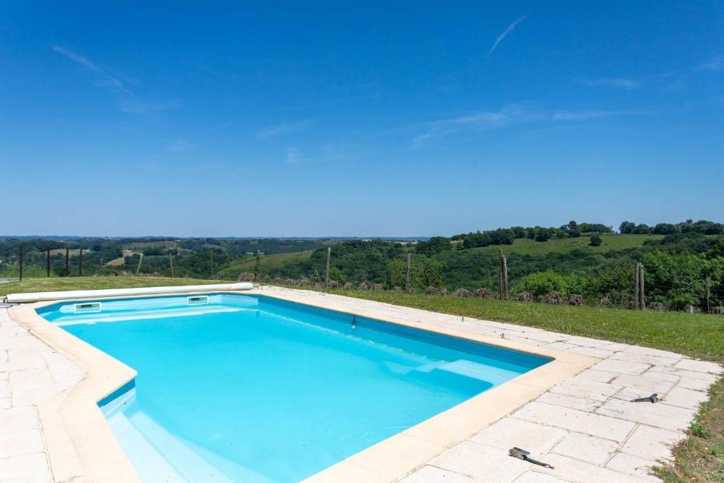 a swimming pool with blue water in a yard at Domaine Cherps Spa - Zen in Vielleségure