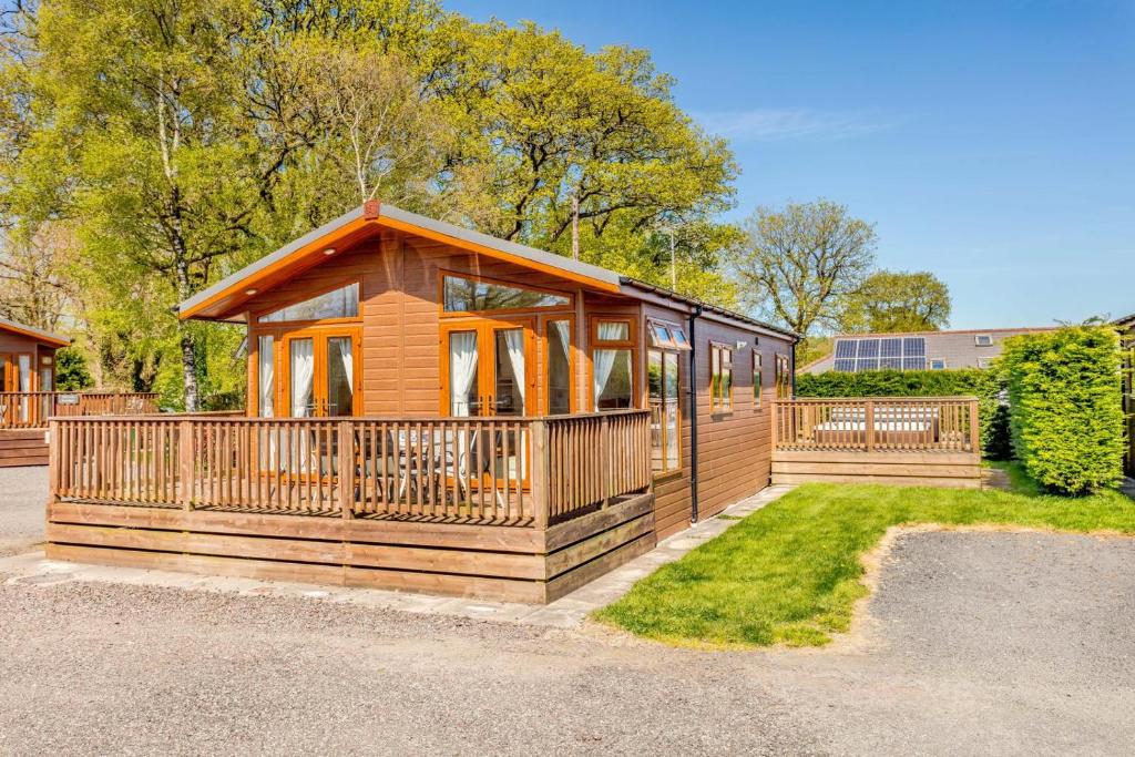 a large wooden cabin with a large deck at 2 Bed in Okehampton oc-80373 in Okehampton