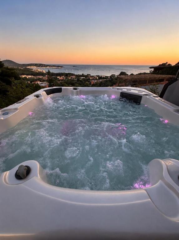 a hot tub with the ocean in the background at Villasimius Il patio sul porto in Villasimius