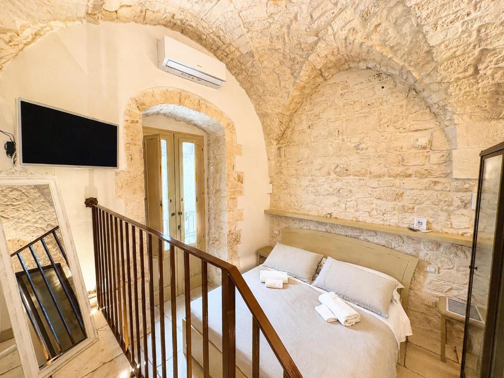 a bedroom with a bed in a stone wall at Il Balcone di Anna - Luxury Homes in Ceglie Messapica