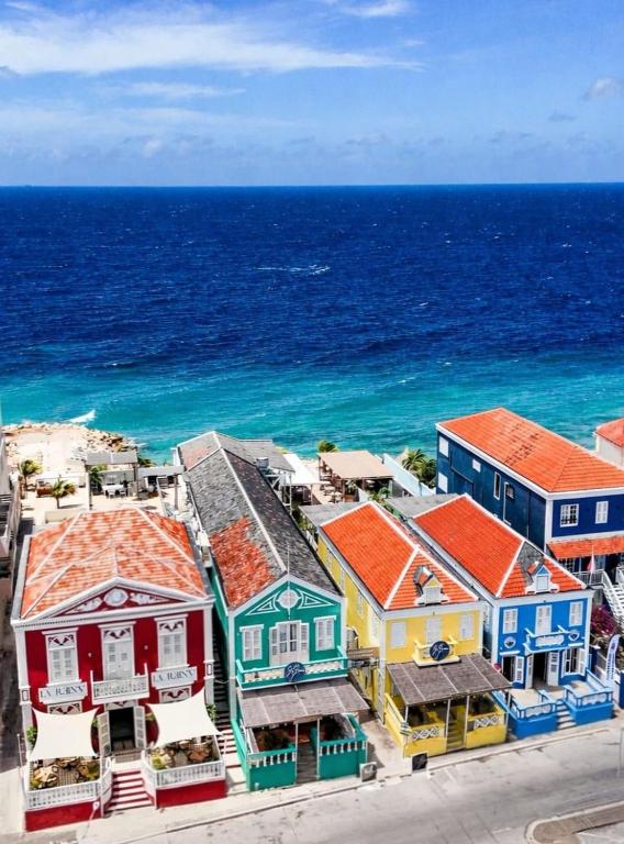 an aerial view of a colorful town next to the ocean at BijBlauw in Willemstad