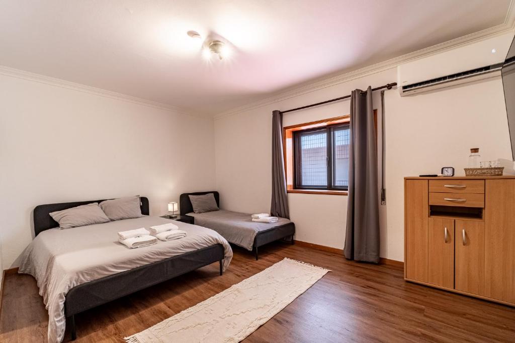 a bedroom with a bed and a desk and a window at Guest House Da Mata in Póvoa de Varzim