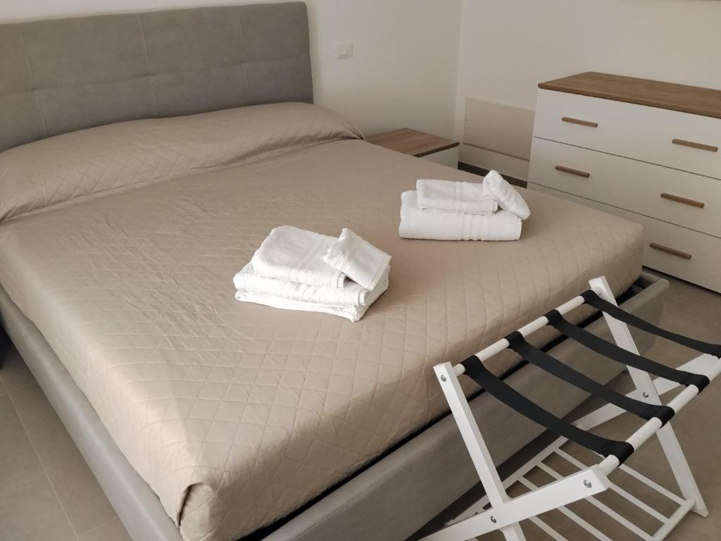 a bed with two towels sitting on top of it at Venice Delta Lagoon Apartments in Porto Viro