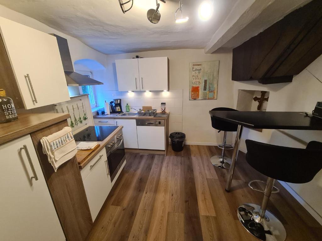 a kitchen with white cabinets and a counter top at Ferienhaus Mia in Neumagen-Dhron