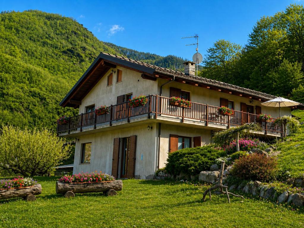 a house with a balcony and flowers in the yard at Joy Center - Casa e Appartamenti Vacanza in Val Pellice in Villar Pellice