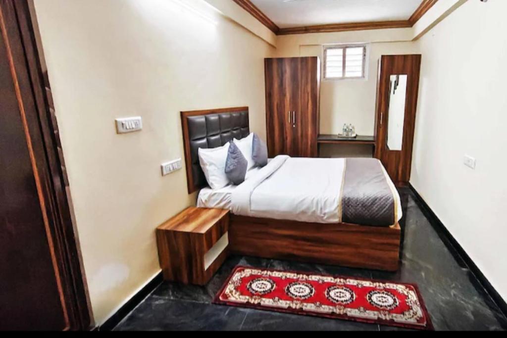 a bedroom with a bed and a red rug at Sri Sai royal suites in Sonda