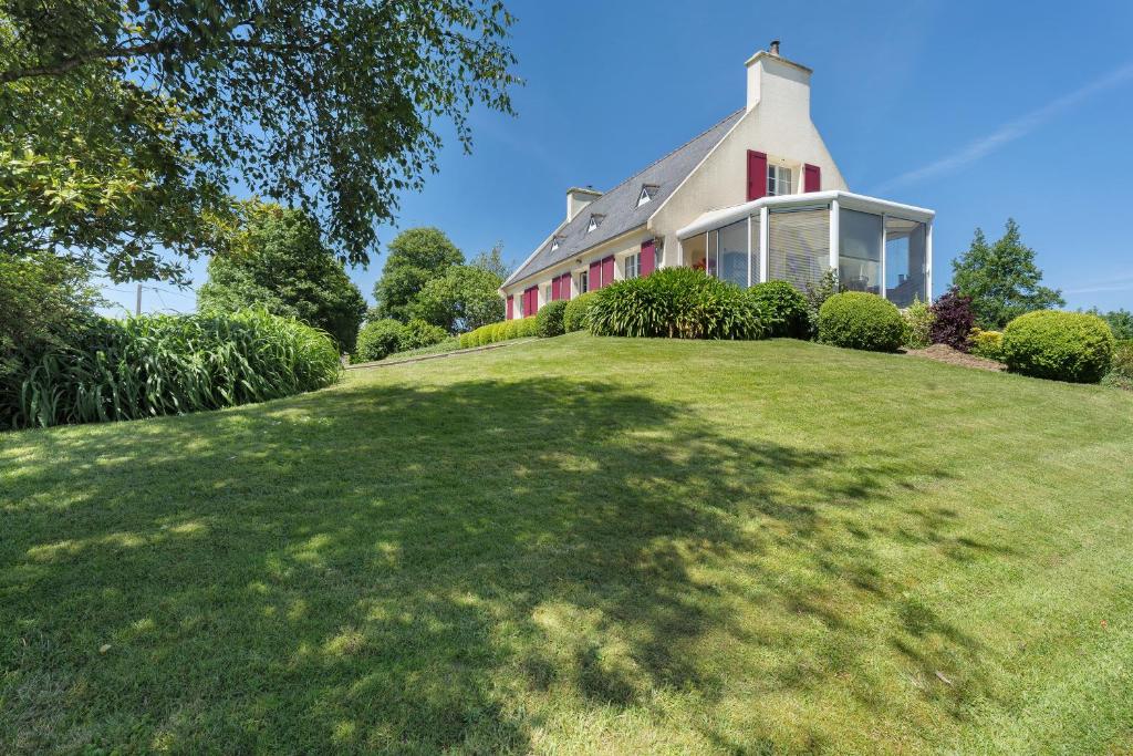 a house on a grassy hill with a large yard at Chambres D'hôtes Kergollay in Lanhouarneau