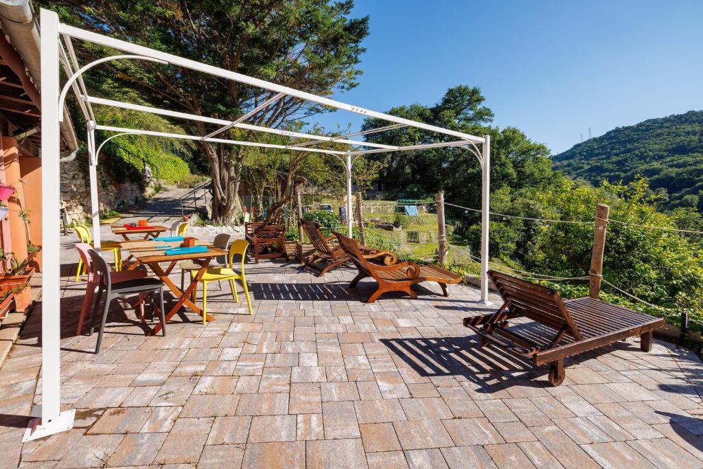 a patio with wooden benches and tables and chairs at Villa Piuma in Finale Ligure