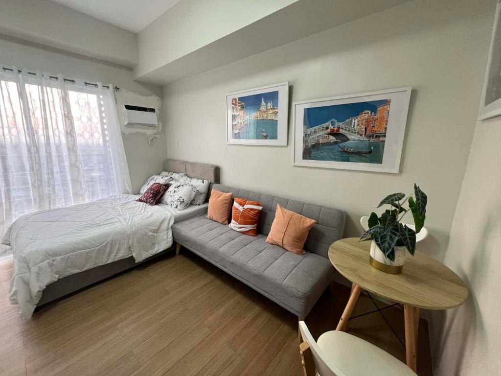 a bedroom with a couch and a bed and a table at Loop Towers by Vista Residences in Pontud