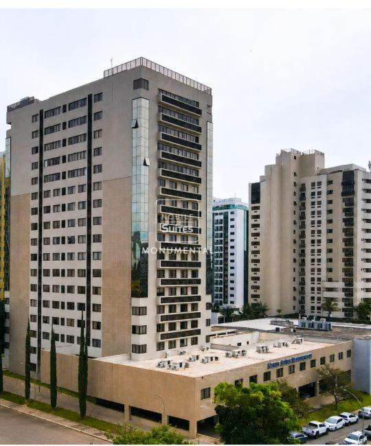 a tall building with cars parked in front of it at Nobile Suites Monumental in Brasília