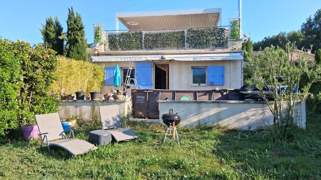 a house with two chairs and a grill in the yard at Chez Mich'An Luberon in Saignon