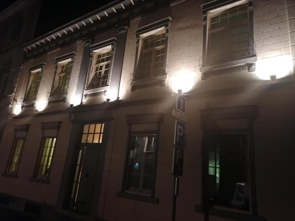a building with lights on the side of it at night at Désir D'un Soir in Lessines