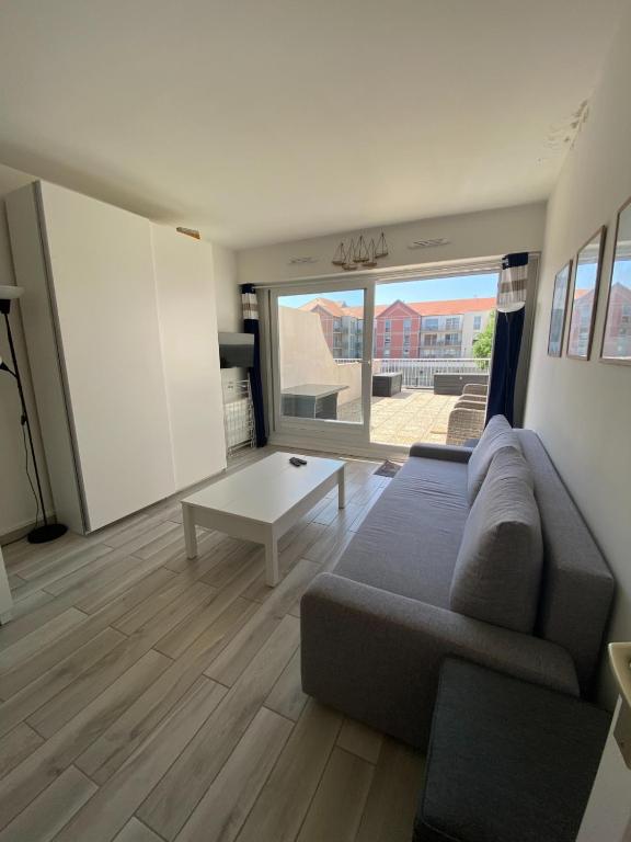 a living room with a couch and a table at Le Sunny Hardelot in Neufchâtel-Hardelot