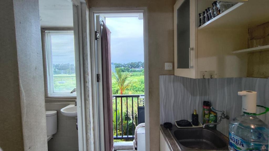 a bathroom with a sink and a toilet and a window at Student Castle Apartement by Dev's Room in Seturan