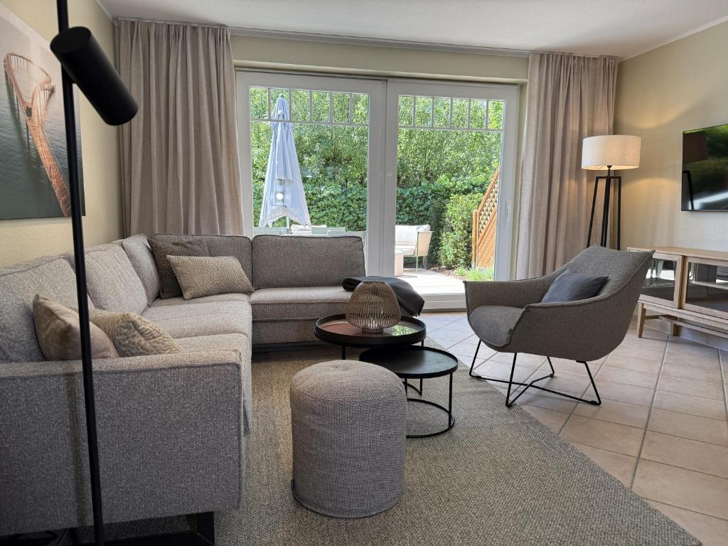 a living room with a couch and two chairs at 4Strandzeiten - Ferienhaus Luv in Timmendorfer Strand